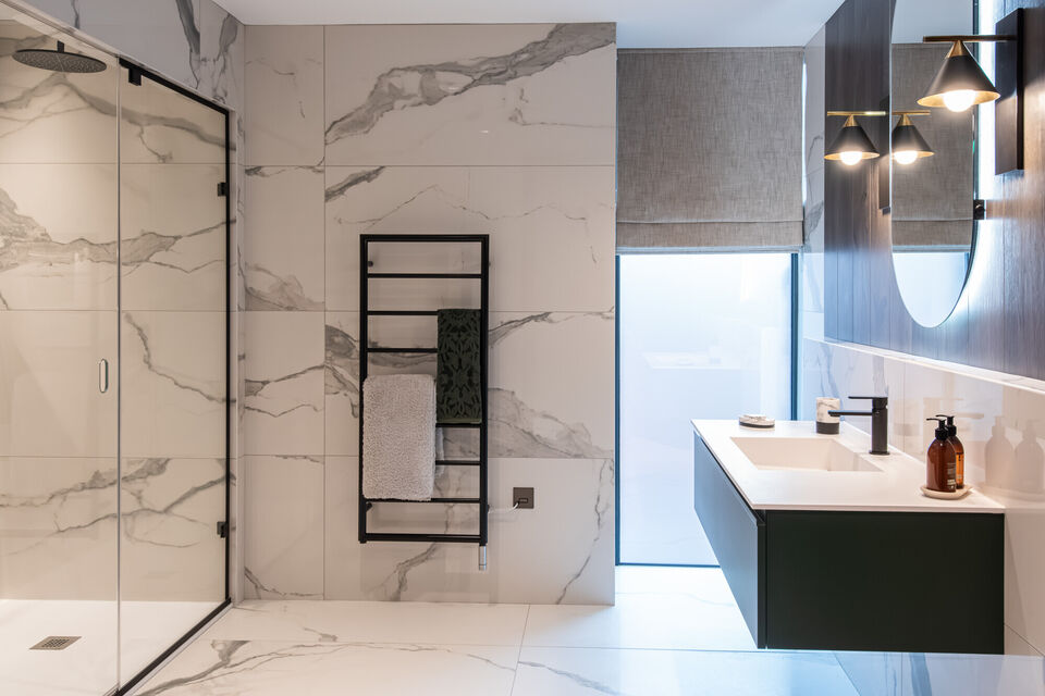 Luxury contemporary bathroom with large-format marble tiles, walk-in shower and floating vanity, black furniture
