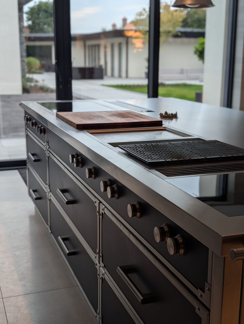 Bespoke kitchen island with professional-grade cooking suite and stainless steel worktop