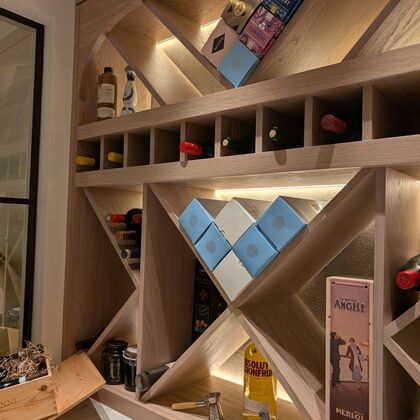 Bespoke oak wine wall with integrated bottle storage, display shelving and feature lighting