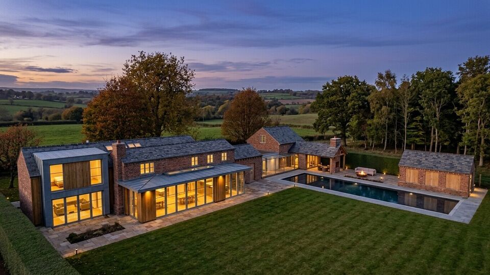 Luxury extension to a Cheshire cottage featuring panoramic floor-to-ceiling windows to the countryside, a glass link, outdoor swimming pool and pool house.